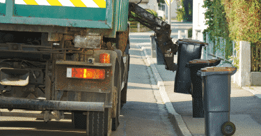 Caminhão compactador coletando lixo