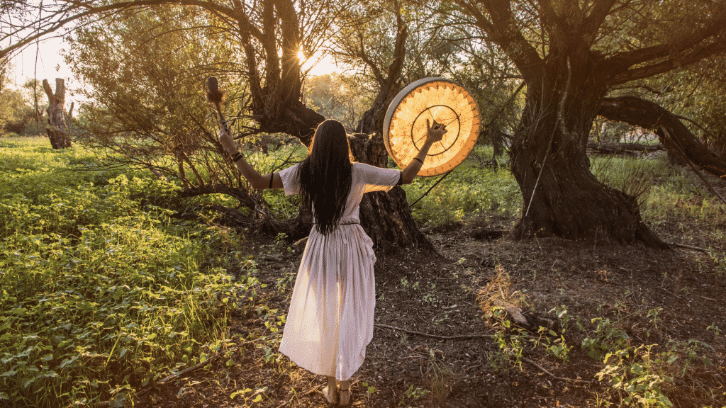 Mulher fazendo ritual xamânico no meio de uma floresta