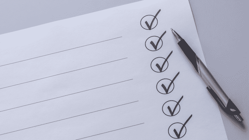 Imagem de um caderno de checklist e uma caneta ao lado