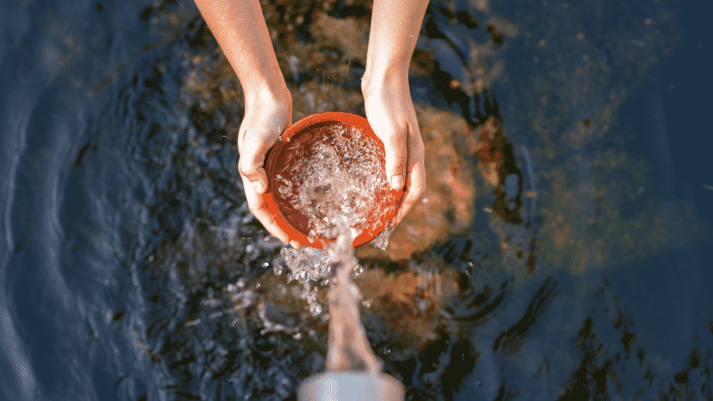 Pessoa enchendo uma cambuca com água limpa