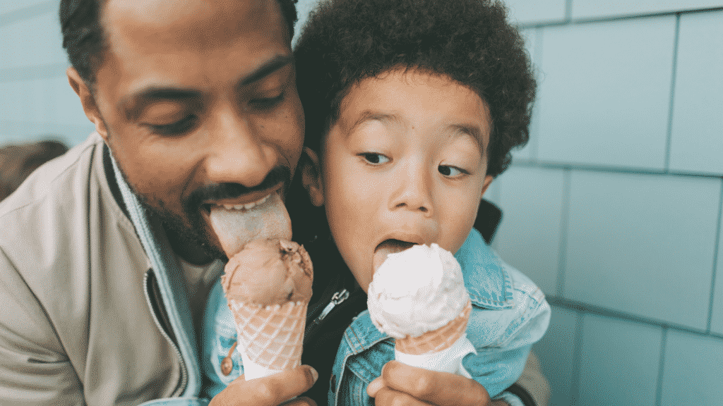 Homem e menino lambendo um sorvete de casquinha