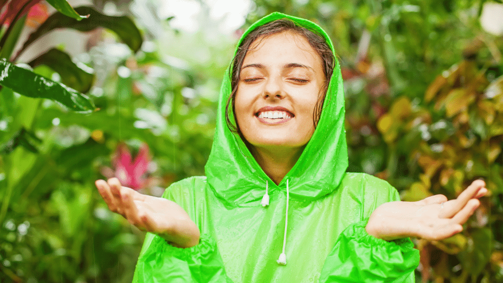 Uma mulher exibindo um rosto de satisfação ao estar em meio à chuva.