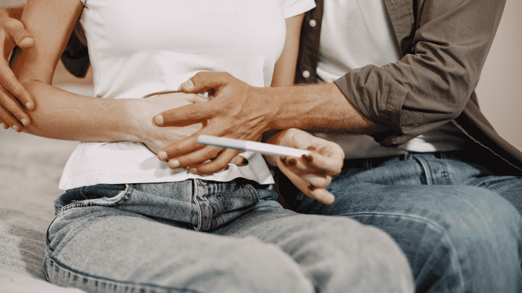 Um casal lendo um teste de gravidez.