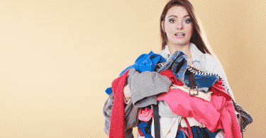 Uma mulher carregando roupas sujas.