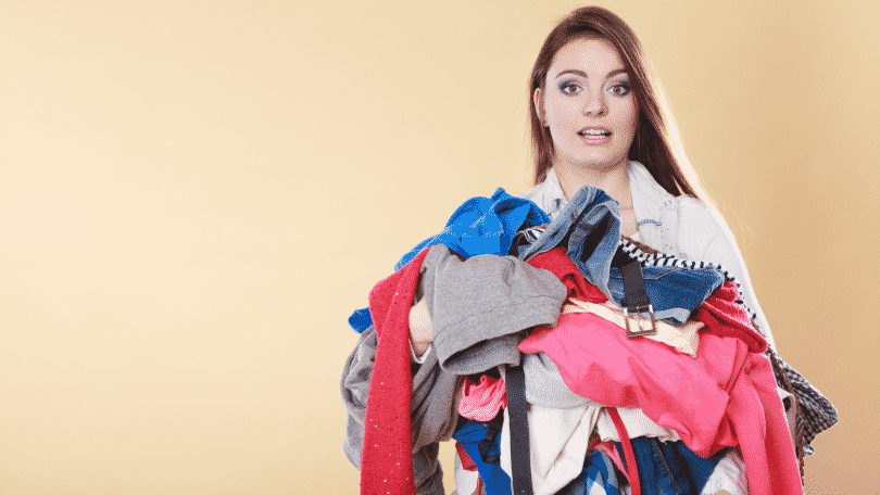 Uma mulher carregando roupas sujas.