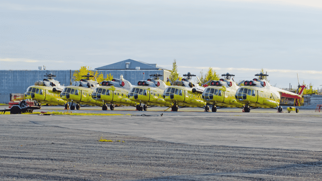 Vários helicópteros amarelos estacionados.