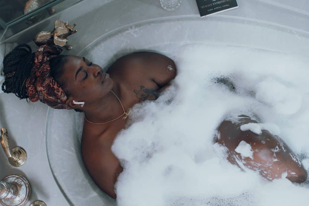 Mulher negra deitada numa banheira.