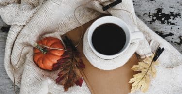 Xícara de café em cima de um caderninho.