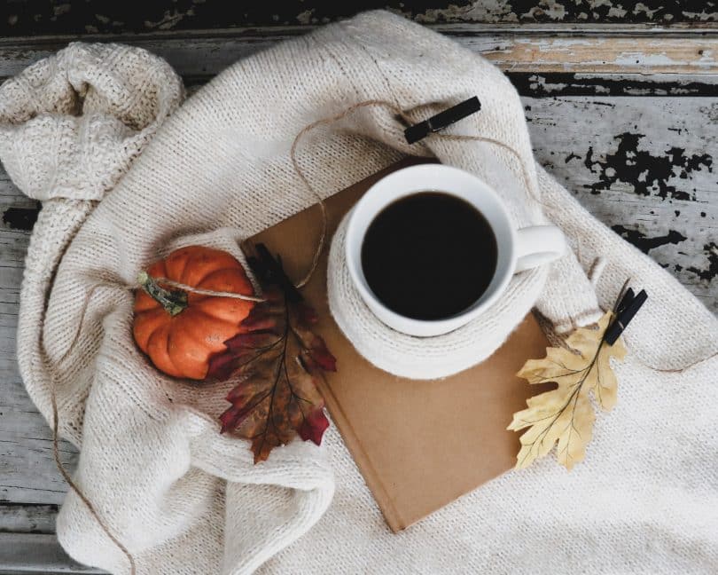 Xícara de café em cima de um caderninho.