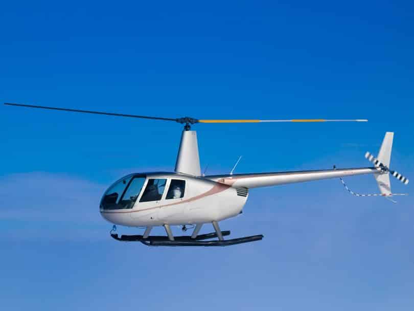 Um helicóptero voando em meio a um céu azul.