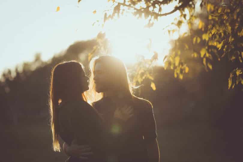 Mulher e homem brancos abraçados.