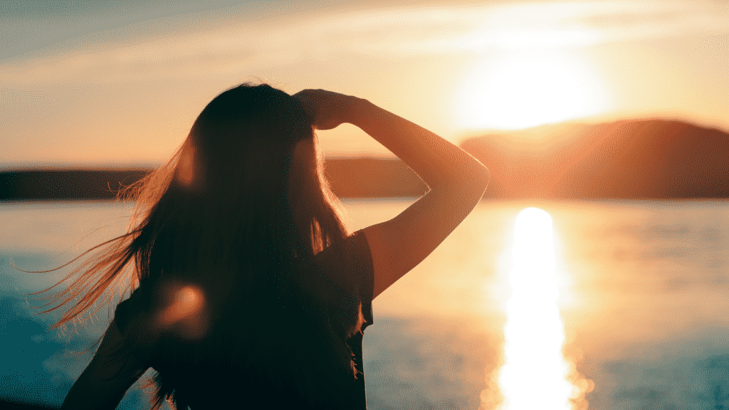 Uma mulher observando um sol forte.