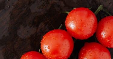 Tomates molhados em uma superfície de madeira.