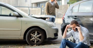 Dois carros batidos e homens preocupados.