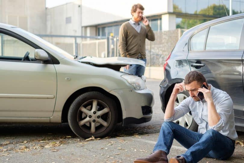 Dois carros batidos e homens preocupados.