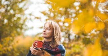 Mulher tomando chá ao ar livre.