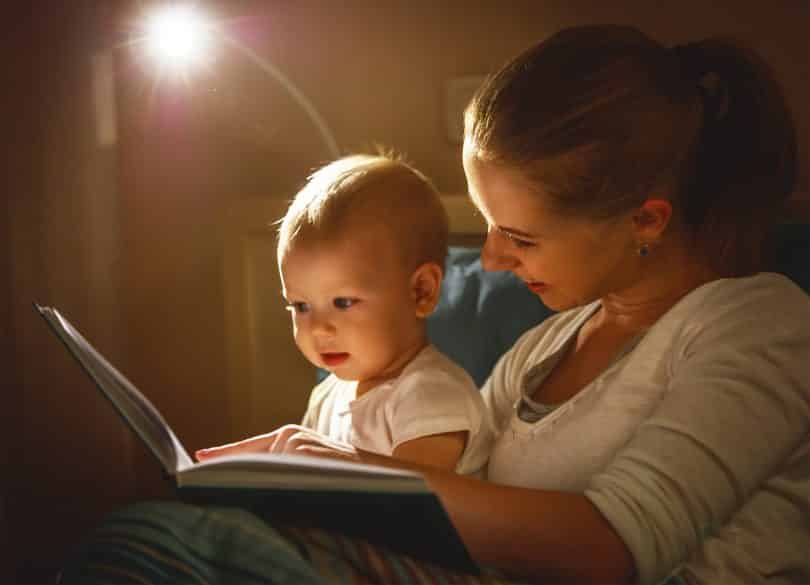 Mãe lendo para seu bebê.