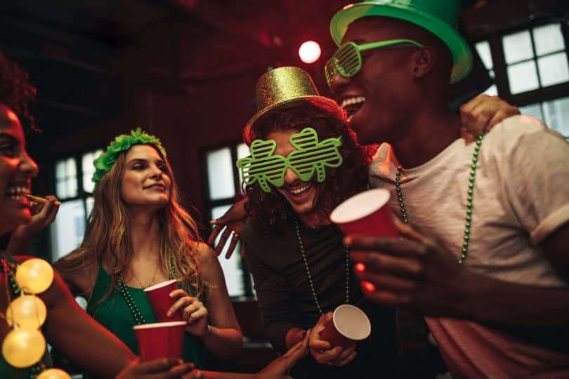 Pessoas celebrando o saint patrick's day em um bar.