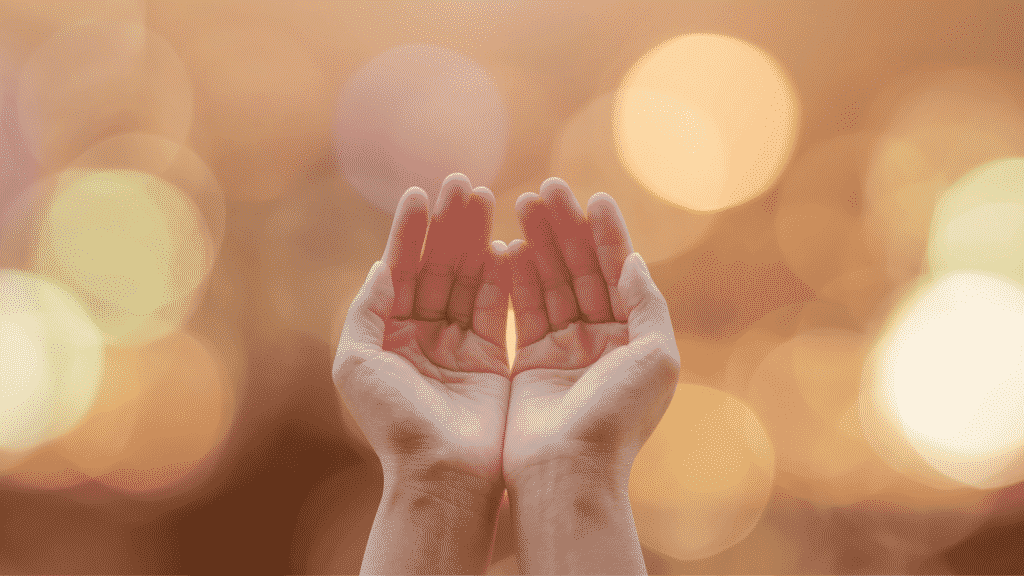 Mãos erguidas em gesto de oração.
