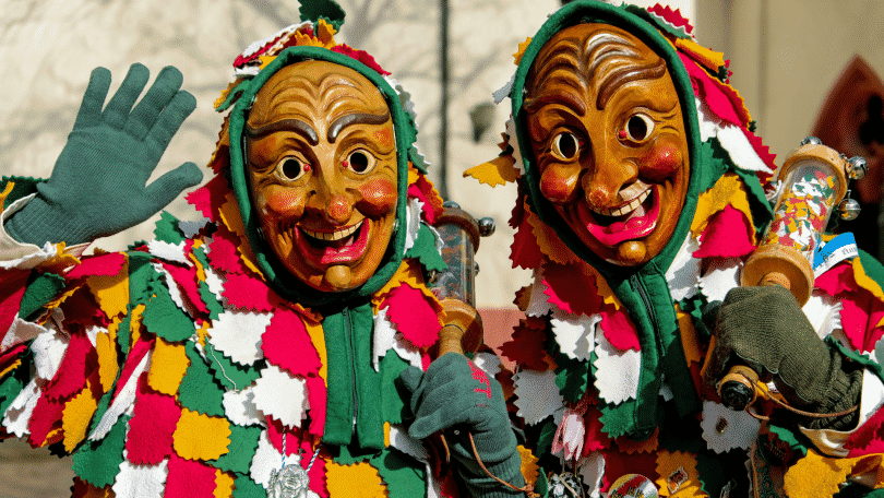 Duas pessoas com máscaras e fantasias de carnaval