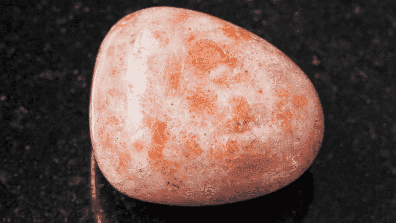 Pedra do sol arredondada sobre uma superfície escura