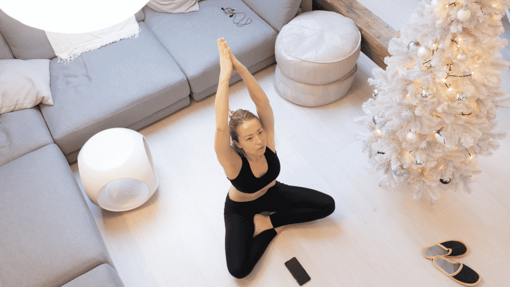 Mulher praticando yoga no meio da sala de estar