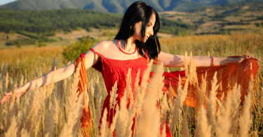 mulher de vestido vermelho no campo