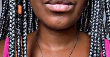 Recorte de um rosto de uma mulher negra com tranças.