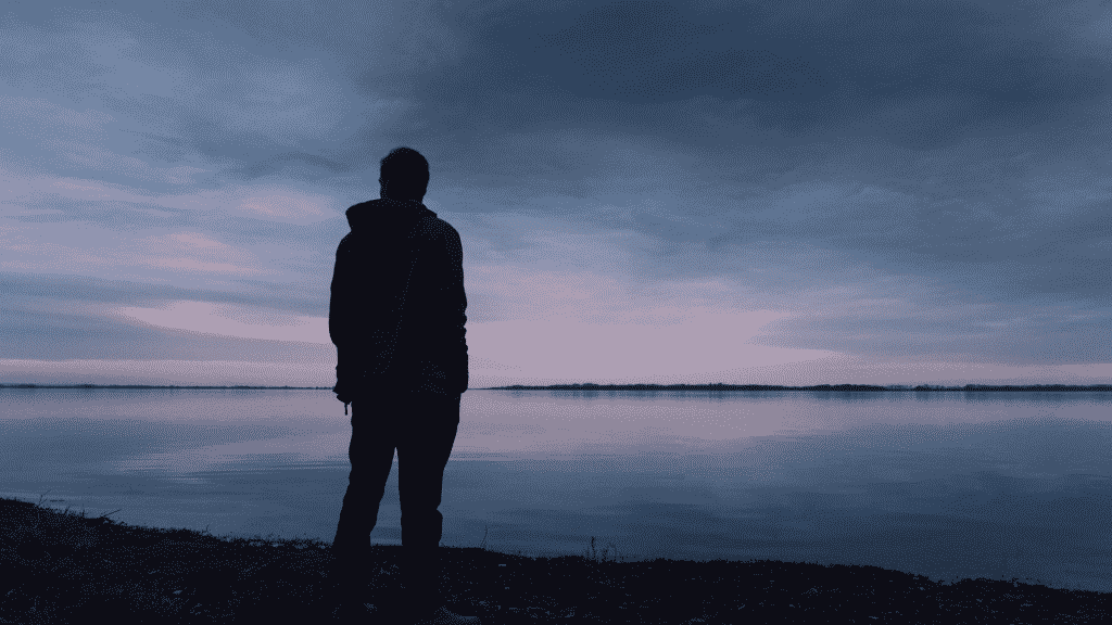 Um homem solitário a contemplar um mar.