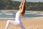 Mulher fazendo alongamento de Yoga na praia.