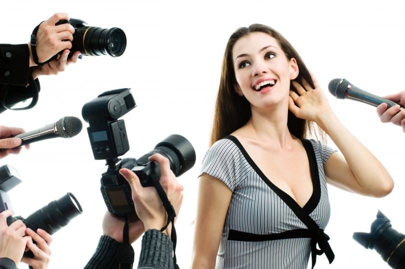 Uma mulher sendo capturada por várias câmeras fotográficas.