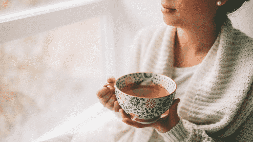 Uma mulher segurando uma xícara de chá.