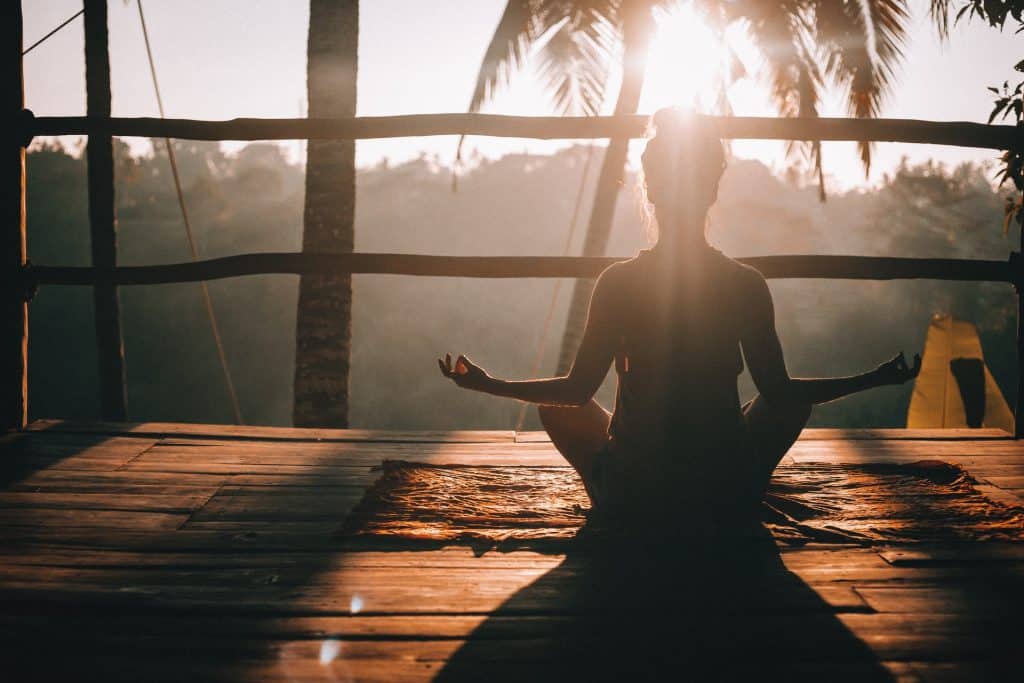 Mulher sentada meditando.