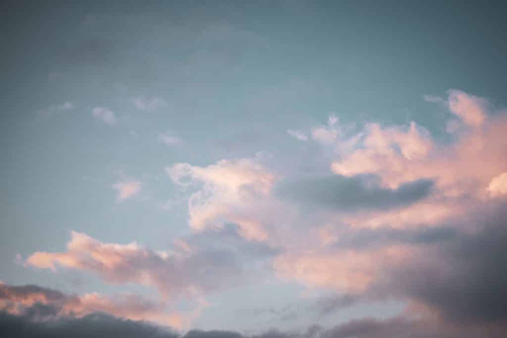 Céu azul com nuvens alaranjadas.