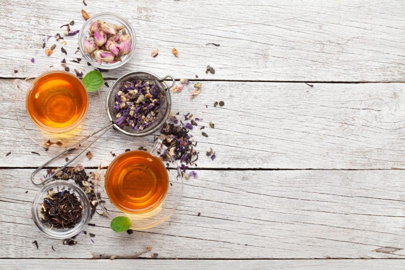 Diferentes tipos de chá dispostos numa tábua de madeira.