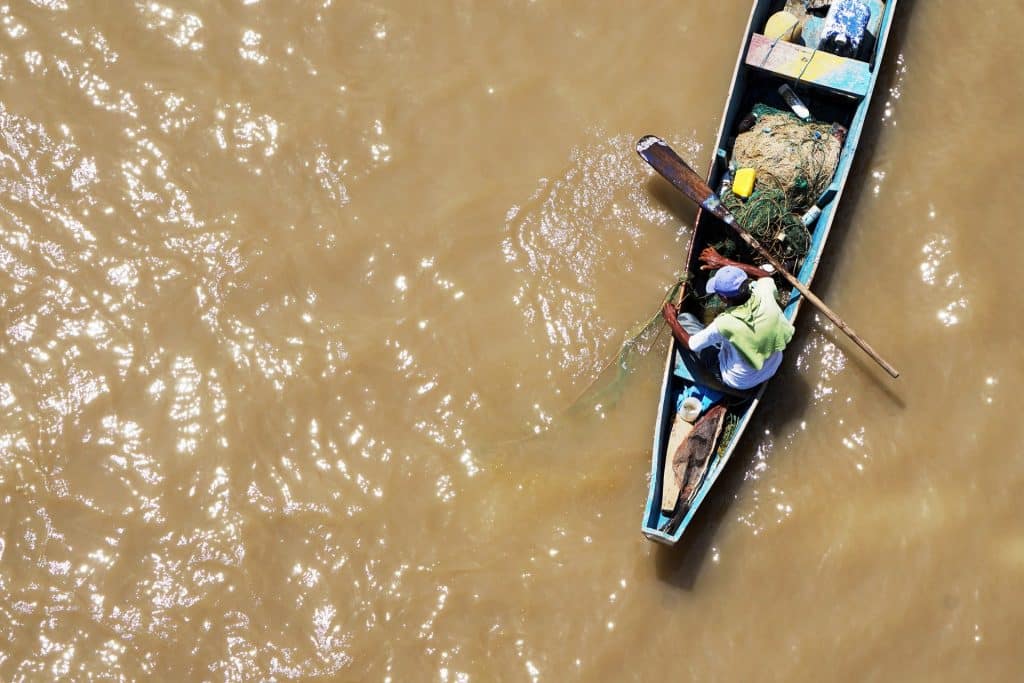 Barco em um lago de água suja de barro.