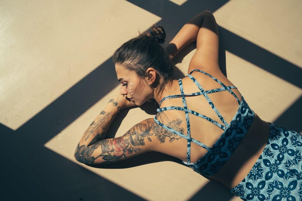 Mulher branca deitada tomando sol.