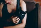 Mulher segurando um gato preto.