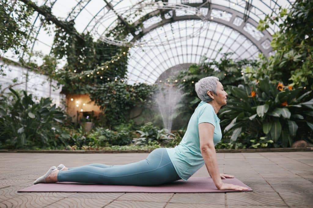 Mulher fazendo a pose da cobra yoga.