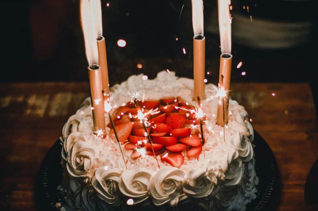 Bolo de aniversário com as velas acesas.