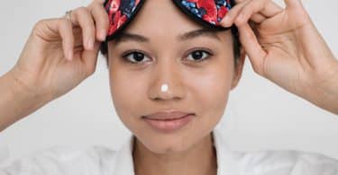 Mulher negra com tapa olhos na testa.