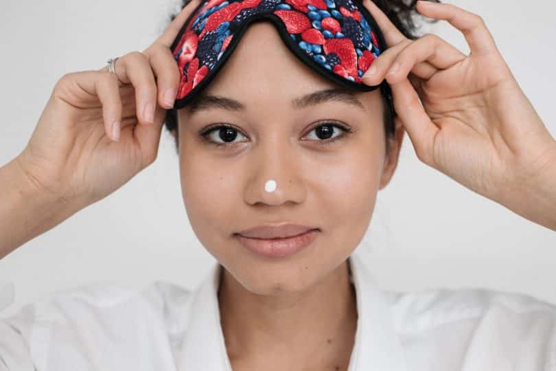 Mulher negra com tapa olhos na testa.