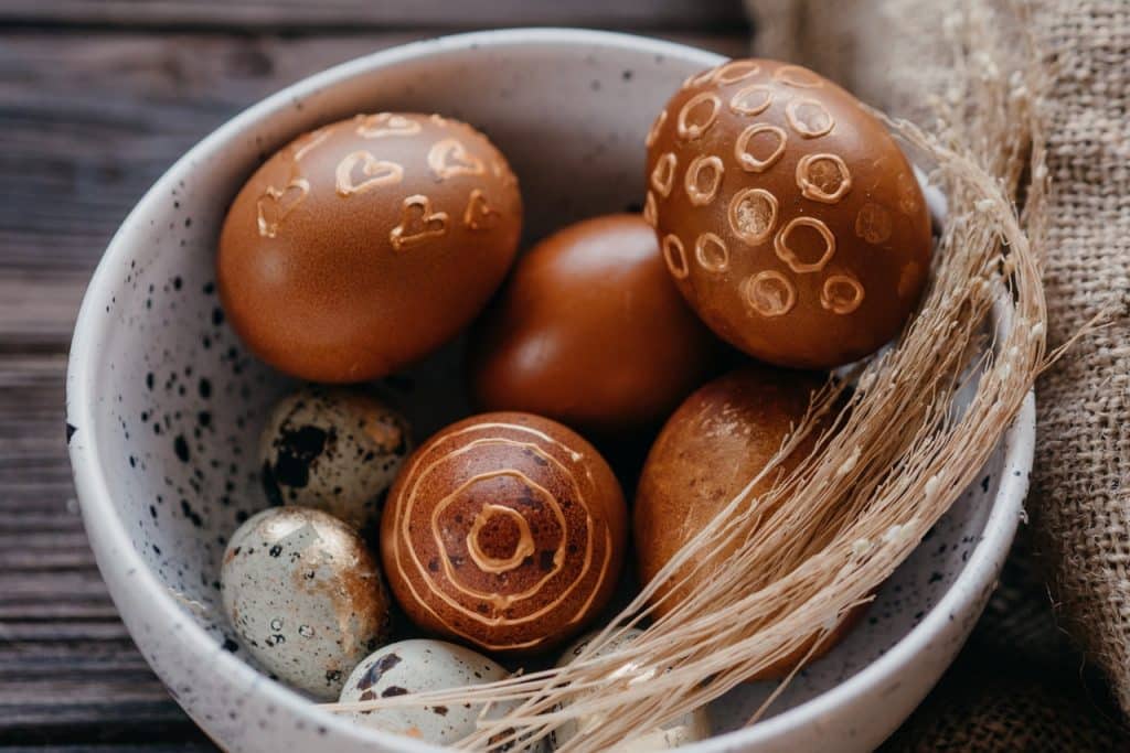 Pote de cerâmica com ovinhos de chocolate.