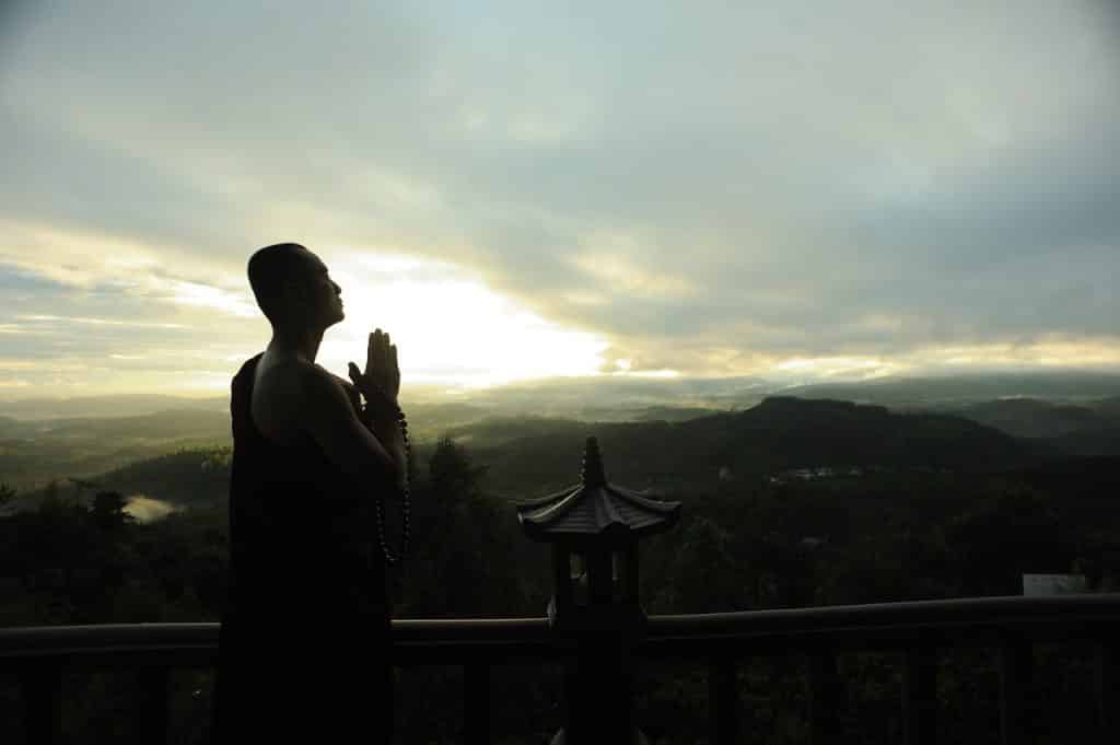 Homem meditando com um japamala.