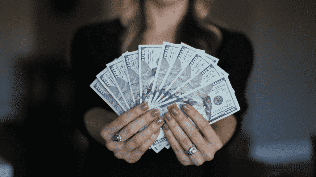 Uma mulher exibindo uma grande quantia de dinheiro.