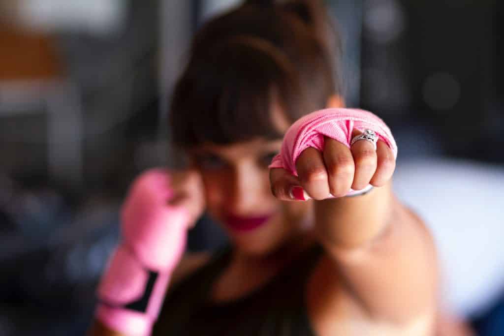 Mulher com luvas de boxe rosas.