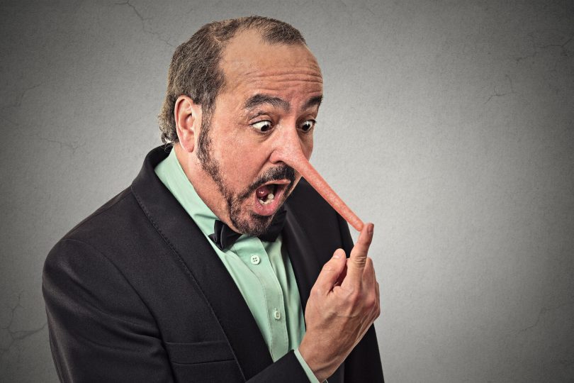 Um homem de smoking realizando uma expressão de surpresa. Seu nariz é grande e pontudo.