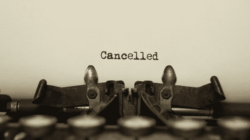 Uma folha de papel numa máquina de escrever. Na folha, a palavra "cancelled" escrita.
