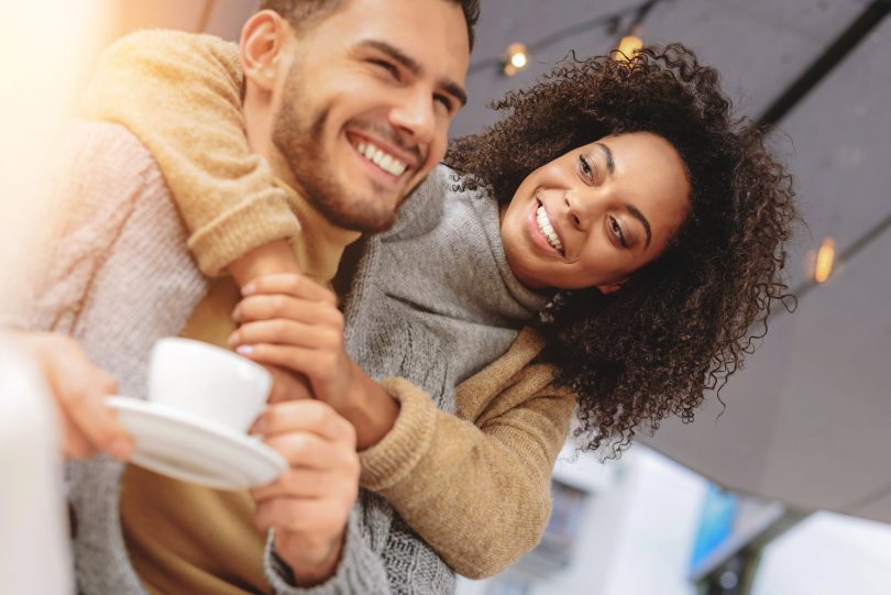 Casal se abraçando e sorrindo.