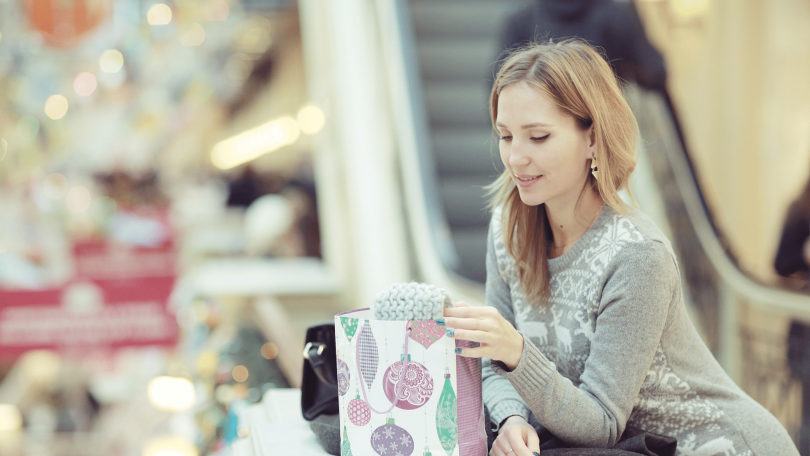 Mulher com uma sacola de presente em um shopping